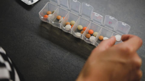 Frau sitzt vor Medikamentendosis