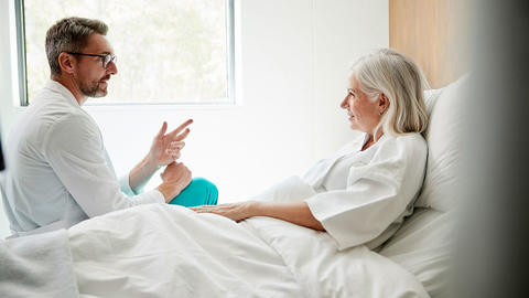 Frau liegt im Krankenhausbett