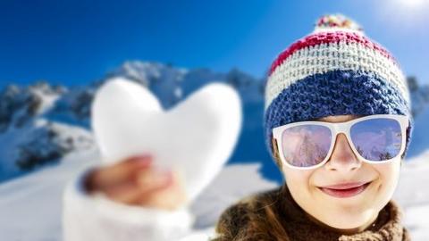 Herz aus Schnee in der Hand eines Kindes