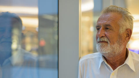 Mann steht vorm Schaufenster und blickt ins leere