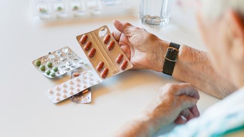 Seniorin schaut sich die Tabletten an 