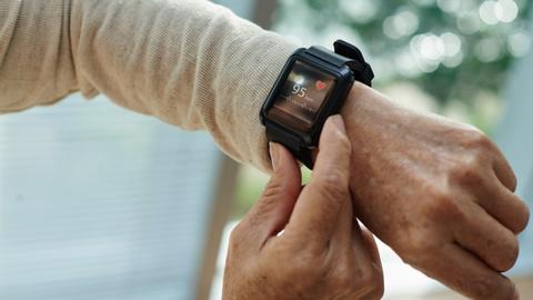 Frau fasst sich an Ihre Smartwatch und überprüft den Puls