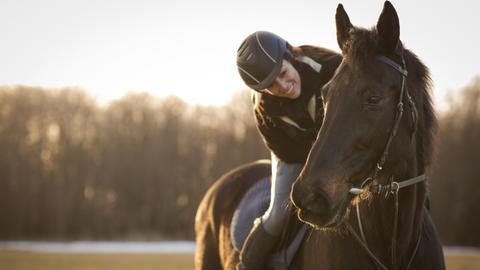Frau reitet auf einem Pferd