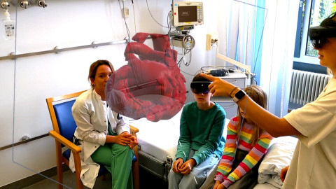 Kinder und Wissenschaftlerinnen des HoloHeart-Projekt-Teams im Uniklinikum Heidelberg beim Testen der HoloHeart-Software am Modell eines Kinderherzens.